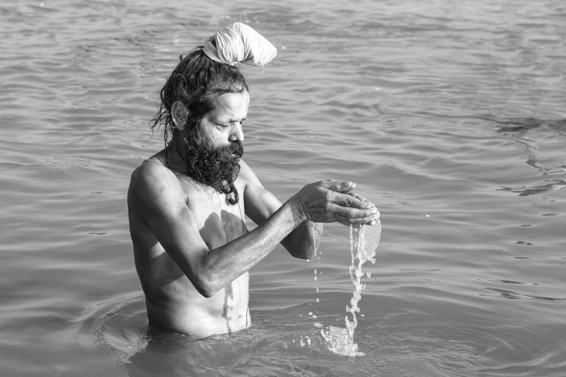 Men and Water Needs from Gender Perspective - holy man performing a religious bath in Sangam at Prayag (Allahabad), Uttar Pradesh